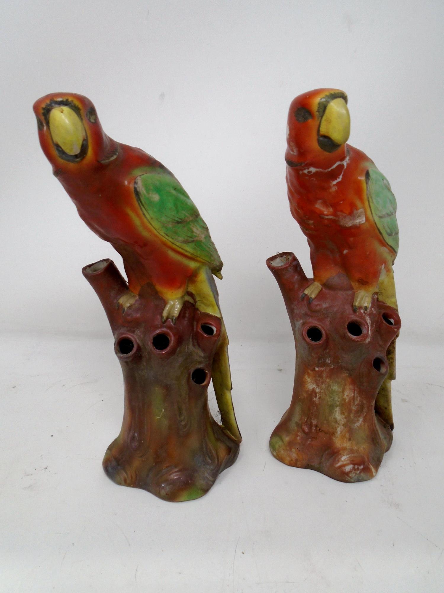 A pair of antique ceramic figures of parrots.