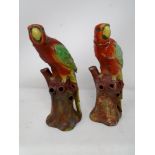 A pair of antique ceramic figures of parrots.