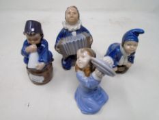 Four Royal Copenhagen figures of children with musical instruments.