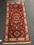 An Iranian red fringed rug,