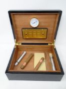 A lacquered humidor containing four cigars,
