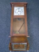 An Edwardian oak wall clock together with an oak mantel clock.