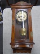 An Edwardian oak Arts and Crafts 8-day wall clock with pendulum and key.