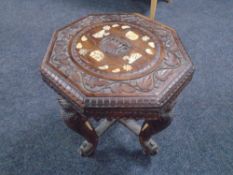 A carved hardwood Indian occasional table on elephant trunk legs.