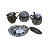 A small pierced silver dish, two silver-lidded pots, a pot lid and an Indian silver jug,