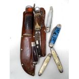 A box containing two hunting knives in leather sheaths together with six further folding pocket