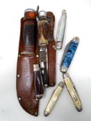 A box containing two hunting knives in leather sheaths together with six further folding pocket