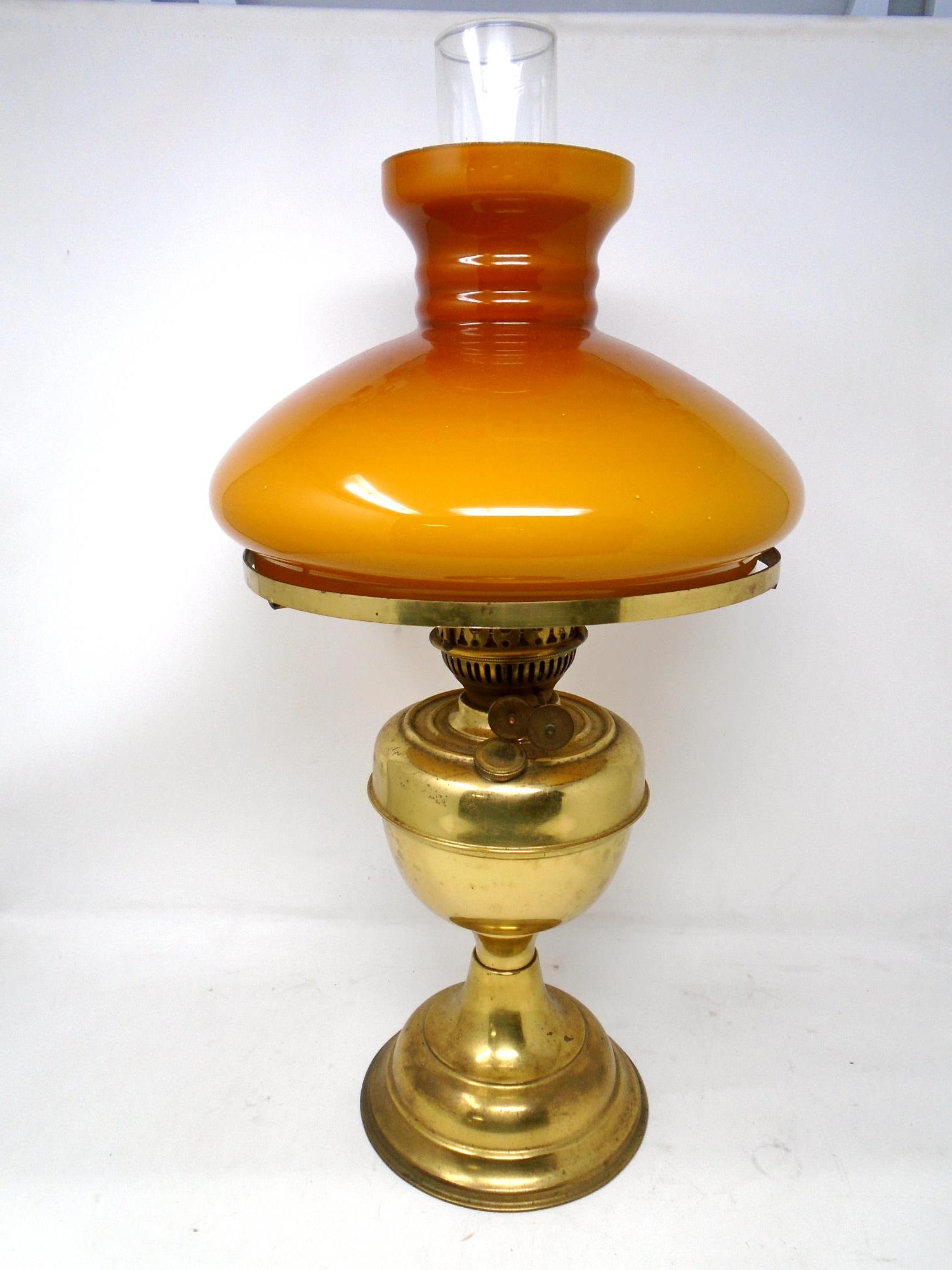 A 20th century brass oil lamp with glass shade.