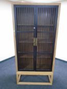 A contemporary oriental style double door cabinet on raised legs