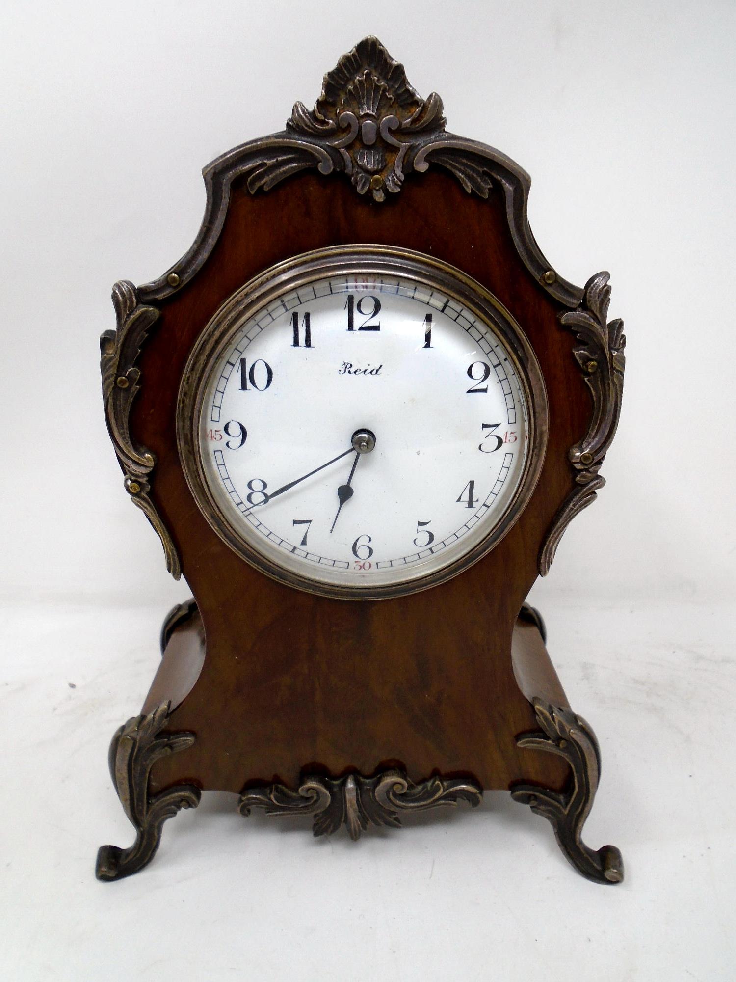 A walnut mantel clock with metal mounts signed Reid.