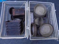 Two wire baskets containing vintage kitchenalia including cake and loaf tins.