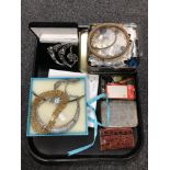 A tray containing tins containing buttons, a leather wallet, lady's wristwatches, costume necklaces.