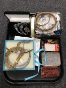 A tray containing tins containing buttons, a leather wallet, lady's wristwatches, costume necklaces.