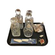 Four cut glass decanters, all with stoppers, all different, together with a china rose ornament,