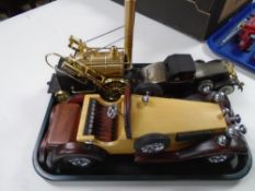 A tray of reproduction Stevenson's Rocket and two model cars.