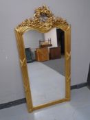 A gilt French-style ornate wall mirror 141 cm x 69 cm