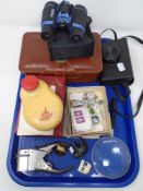A tray of stamps, magnifying glass, field binoculars,
