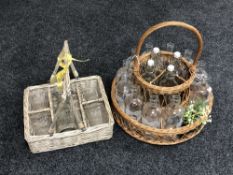 Two wicker carrying crates containing glass bottles and glass.