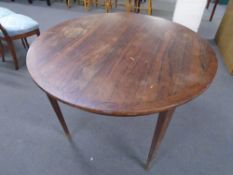 A mid-20th century rosewood circular extending dining table (no leaf).