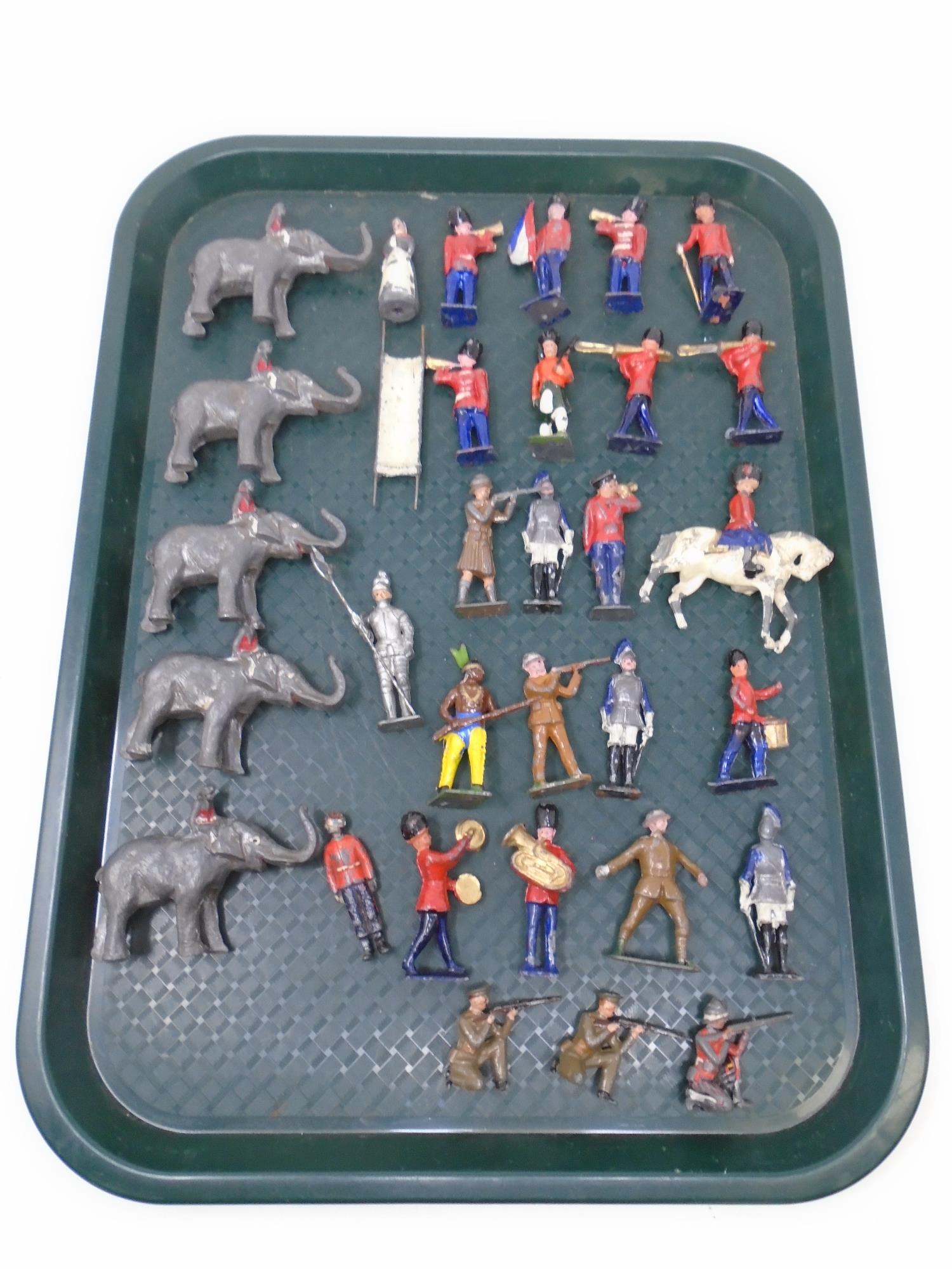 A tray containing mid-20th century painted lead military figures, bandsmen, figures on elephants.