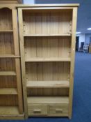 A contemporary oak open bookcase fitted with two drawers.