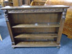 A set of carved oak open bookshelves on bun feet