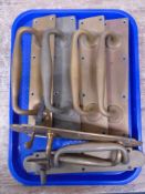 A tray containing three pairs of antique brass door handles.