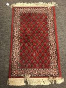 A small machined Persian design rug, 100cm by 62cm.