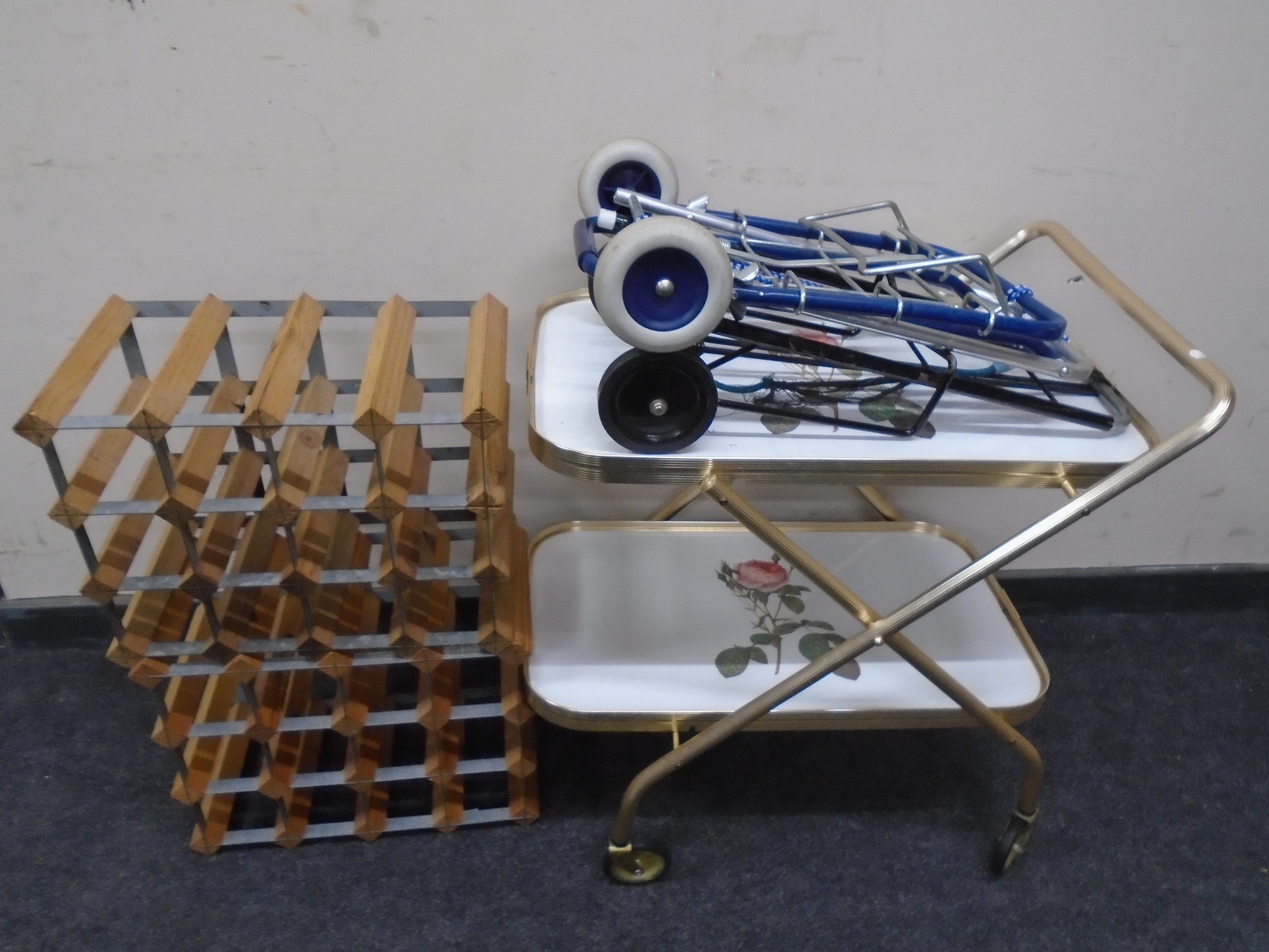 A gilt metal trolley together with two further folding trolleys and two wine racks.