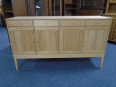 A Scandinavian four door, four drawer sideboard on raised legs.