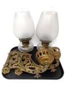 A pair of antique brass wall brackets with glass paraffin lamps.