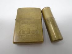 A brass trench art lighter together with a further brass Zippo Marlboro lighter.