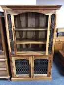 A sheesham wood bookcase fitted with double door cupboard below and wrought iron panels.