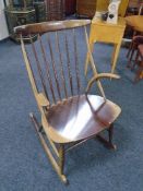 A mid century beechwood stick back rocking chair