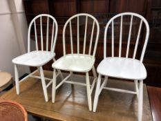 A set of three mid century painted spindle backed dining chairs