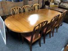 A Sutcliffe furniture oval teak extending dining table fitted with a leaf together with a matching
