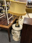 A ceramic elephant plant stand together with a brass and marble table lamp with shade.