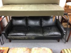 A 20th century Scandinavian three seater settee upholstered in black leather.