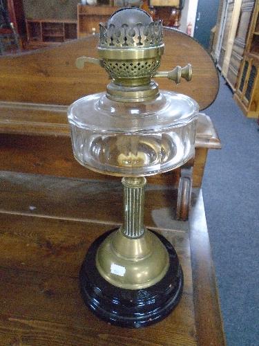 A Victorian oil lamp with Corinthian column and clear glass reservoir