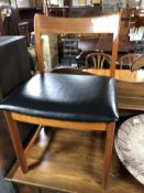 A mid-20th century teak dining chair with black vinyl seat.