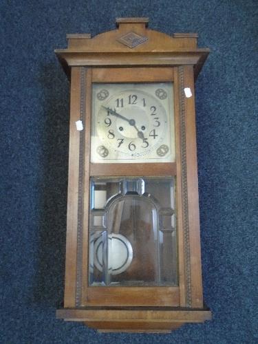 An Edwardian mahogany wall clock with pendulum