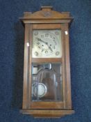 An Edwardian mahogany wall clock with pendulum