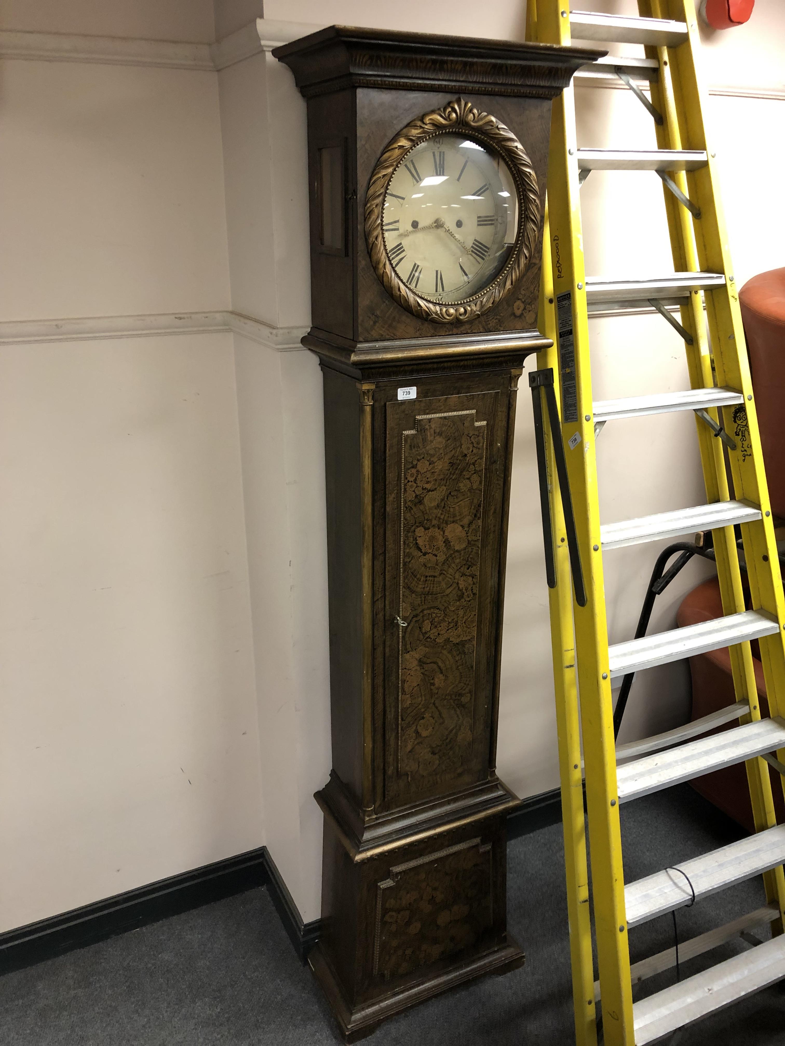 A continental longcase clock in scumbled case, circular dial, pendulum and weights.