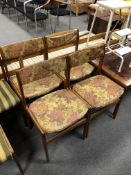 A set of four mid-20th century Danish teak dining chairs upholstered in a floral fabric.
