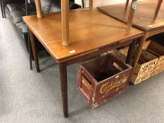 A mid-20th century teak square extending dining table