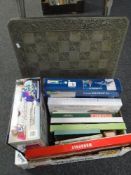 A box of board games including Monopoly, Scrabble, a Chessboard, Revel model etc.