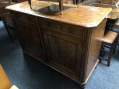 A 19th century mahogany double door sideboard fitted with two drawers above on bun feet.