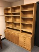 A 20th century Scandinavian open bookcase fitted with cupboards and drawers beneath (width 172cm).