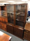 A mid century Danish rosewood glazed double door bookcase fitted with cupboards,