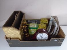 A box containing a brass magazine rack, a pair of candle sticks, a mantel clock, tins etc.